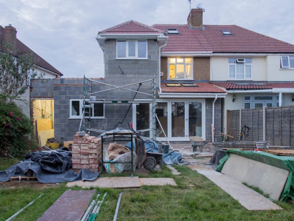 Huis met steigers en bouwmateriaal in de achtertuin
