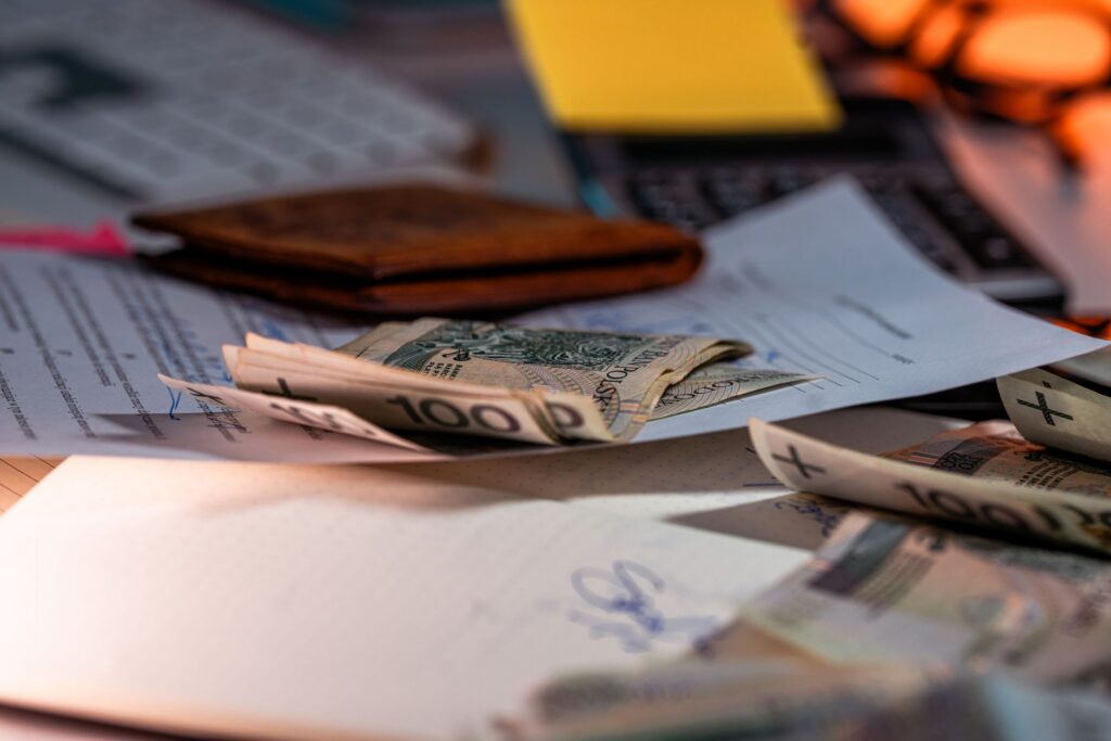 Bankbiljetten en papieren verspreid over een bureau