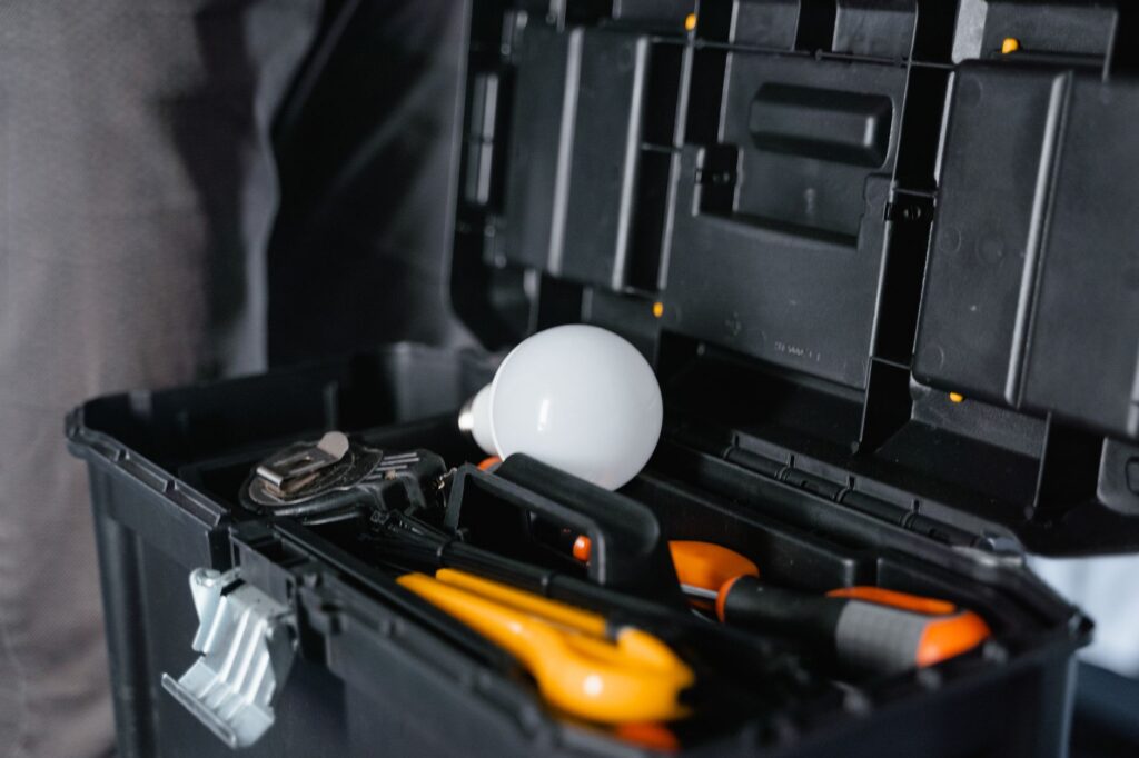 Open gereedschapskist met gereedschap en een gloeilamp