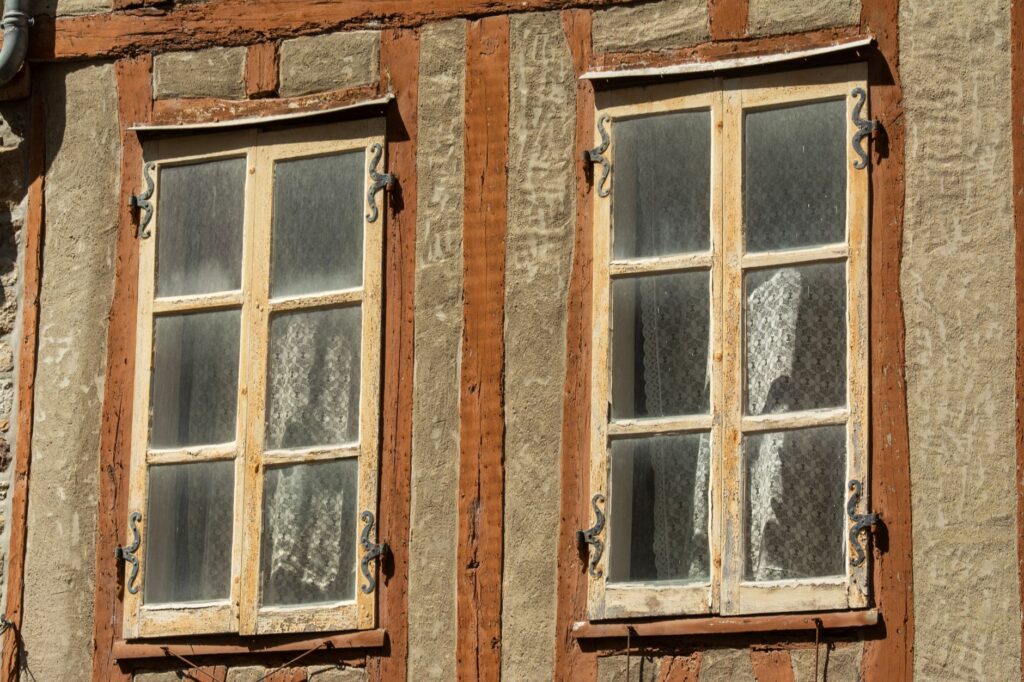 Oude houten ramen in een verweerde gevel