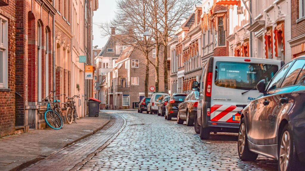 Straat met kinderkopjes, fietsen en geparkeerde auto's